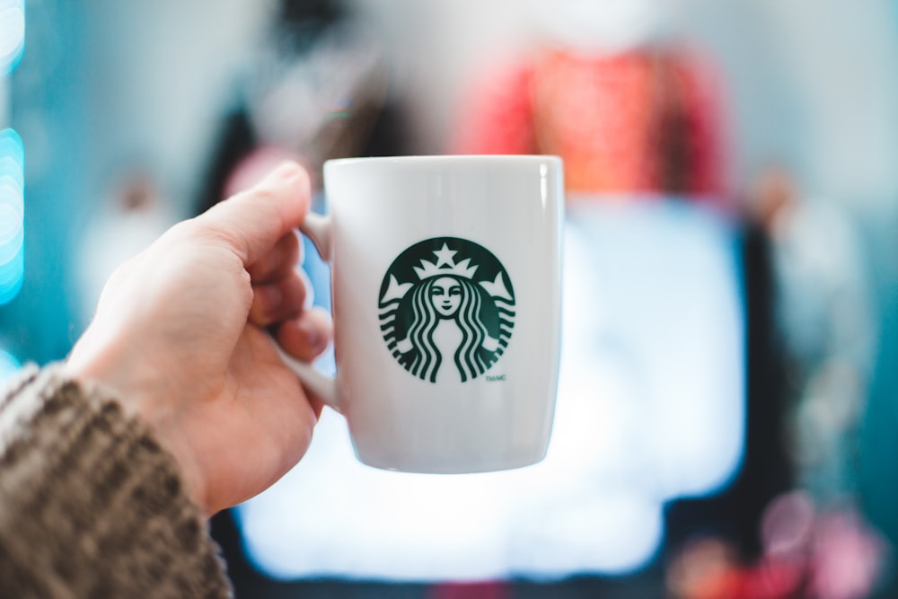 person holding white ceramic mug