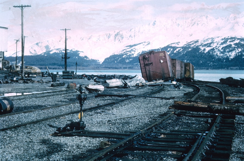 昼間、雪山近くの線路を走る赤と黒の列車