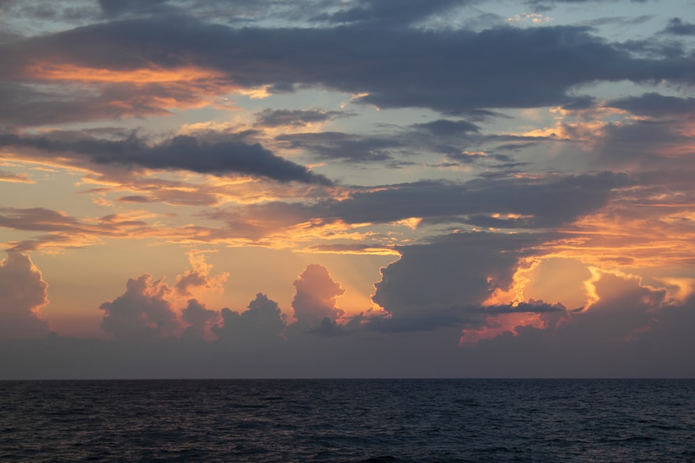 Gewässer unter bewölktem Himmel bei Sonnenuntergang