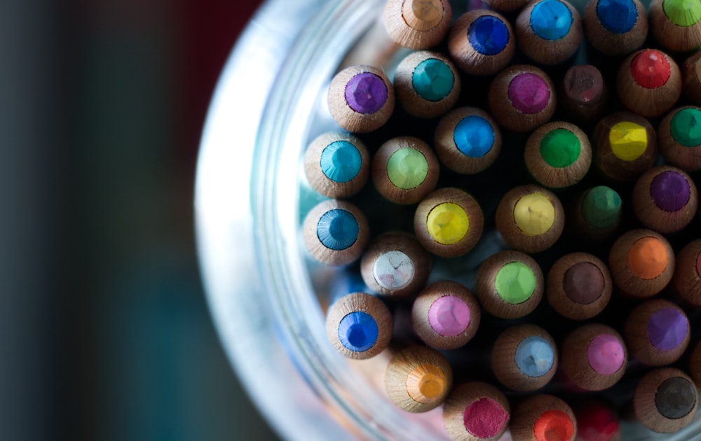 Crayons de couleur multicolores dans un pot en verre transparent