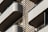 Modern architectural design featuring multiple balconies with smooth, curved edges. The structure incorporates horizontal slats and railings, providing a sleek, geometric appearance. Neutral tones enhance the minimalistic and sophisticated aesthetic.