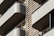 Modern architectural design featuring multiple balconies with smooth, curved edges. The structure incorporates horizontal slats and railings, providing a sleek, geometric appearance. Neutral tones enhance the minimalistic and sophisticated aesthetic.