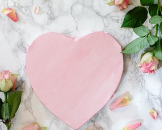 pink heart shaped paper on white and pink floral textile