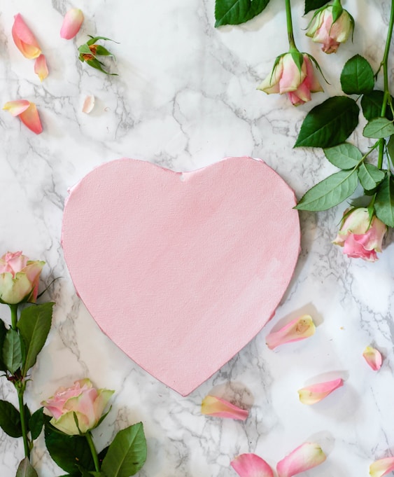 pink heart shaped paper on white and pink floral textile