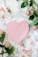 pink heart shaped paper on white and pink floral textile