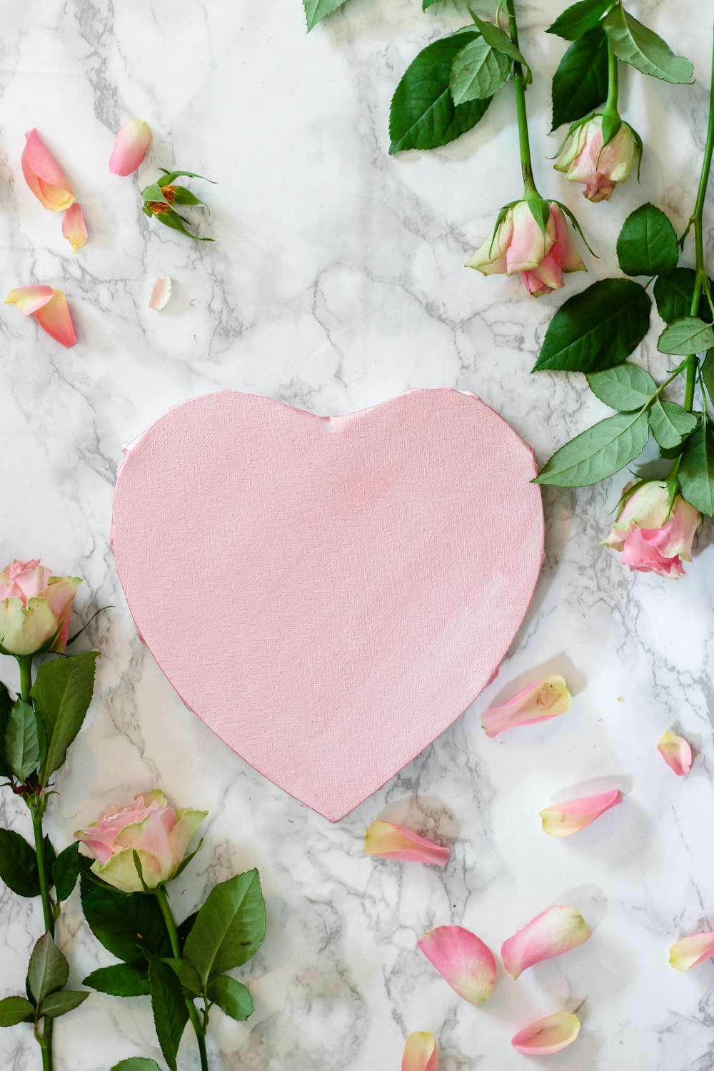 Pink heart shaped paper on white and pink floral textile photo