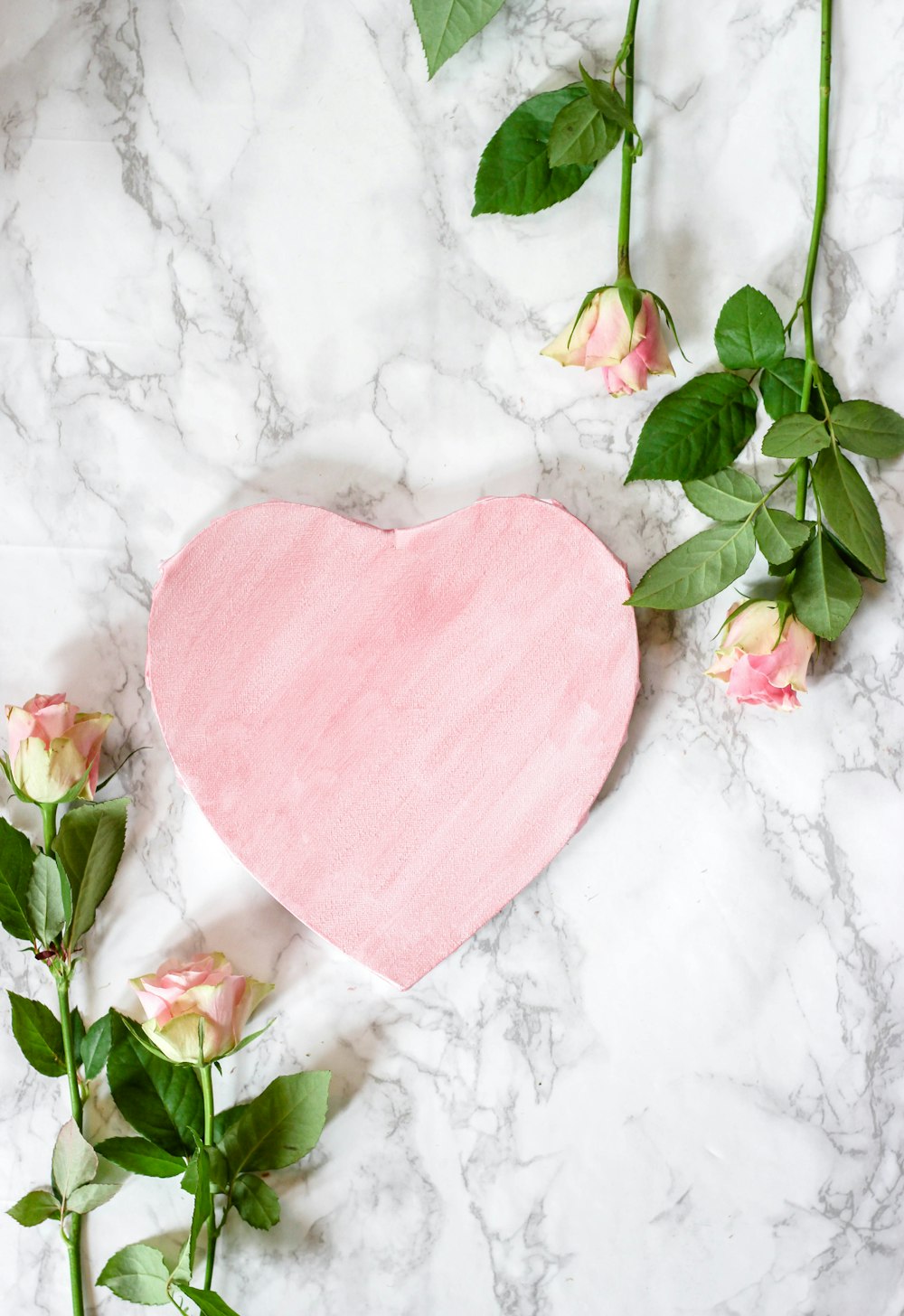 pink heart shaped textile on white floral textile