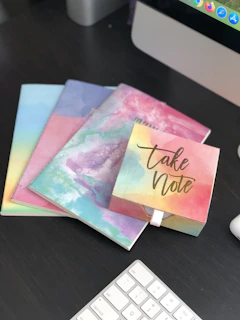 A stack of fun educator cards next to a notebook and colored pencils, inviting creative learning moments.