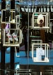 A luxurious retail display with illuminated shelves showcases a pair of gray shoes with red and blue stripes, a white knit hat on a mannequin stand, and a branded shopping bag with a small box. The reflective surfaces create a sophisticated and modern aesthetic.