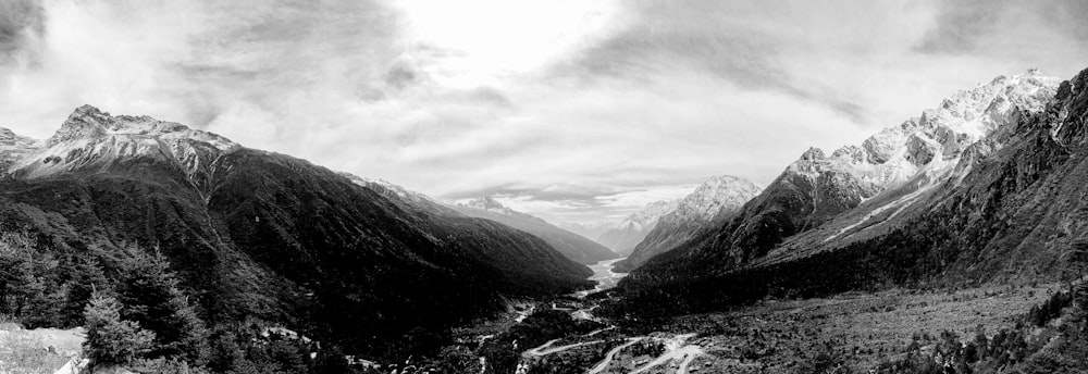 grayscale photo of mountains and river