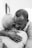 A heartfelt embrace between two people, one with short gray hair and the other with close-cropped hair. The setting appears intimate, suggesting comfort and warmth.
