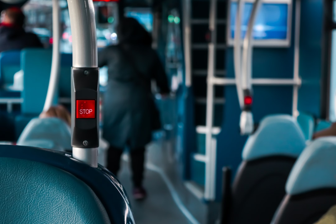 person in black jacket standing in front of blue train