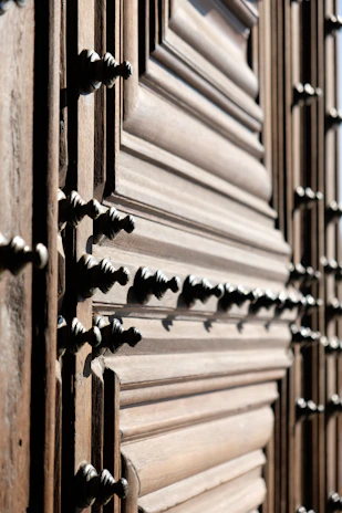 Close-up of handcrafted wooden door with intricate details in a cozy workshop.