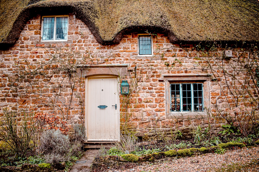 blue wooden door on brown brick house