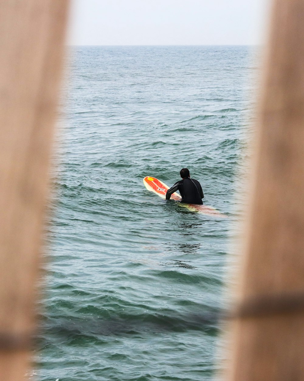 person in black wet suit riding yellow kayak on sea during daytime