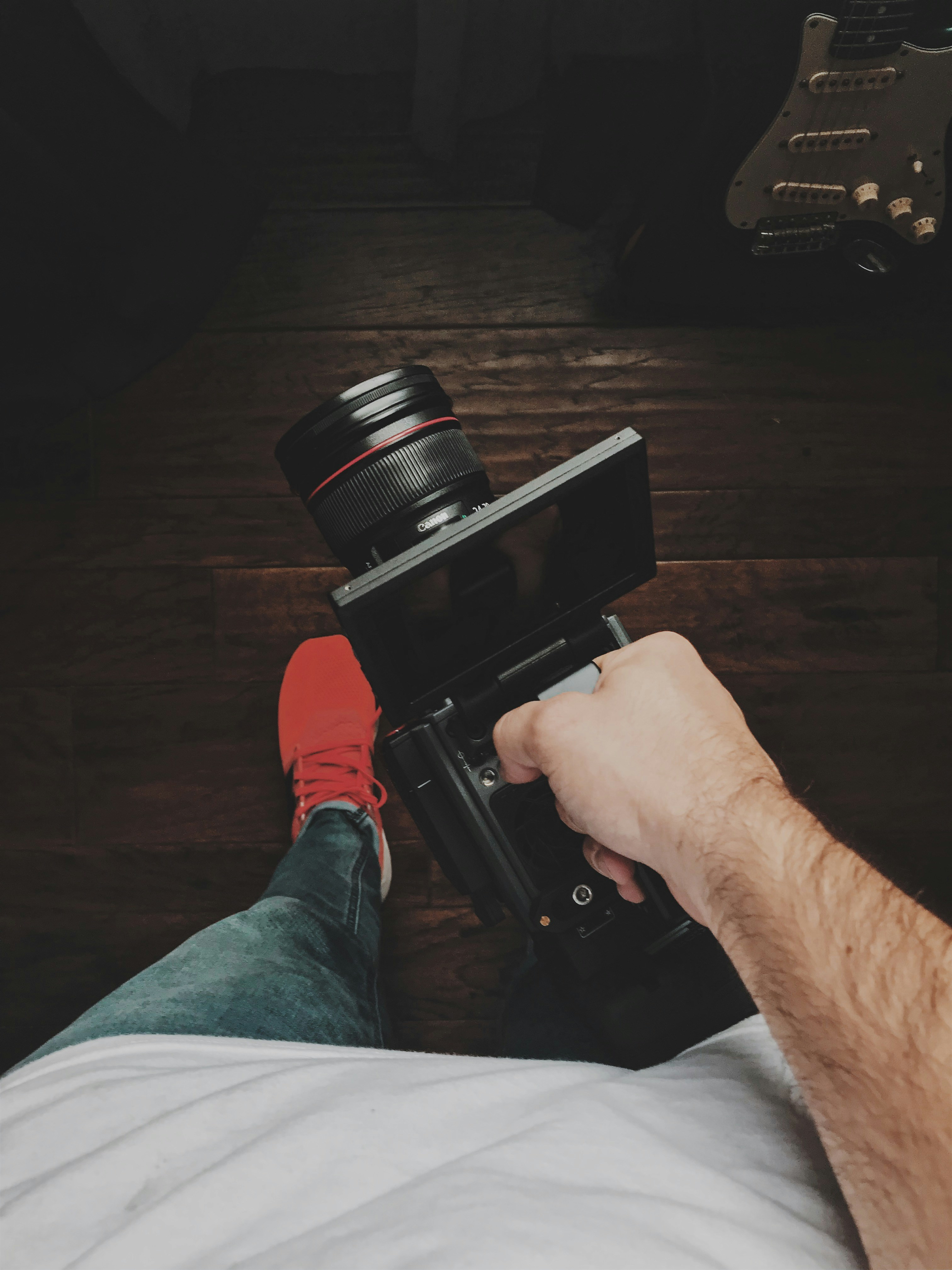 Orang yang memegang kamera DSLR hitam