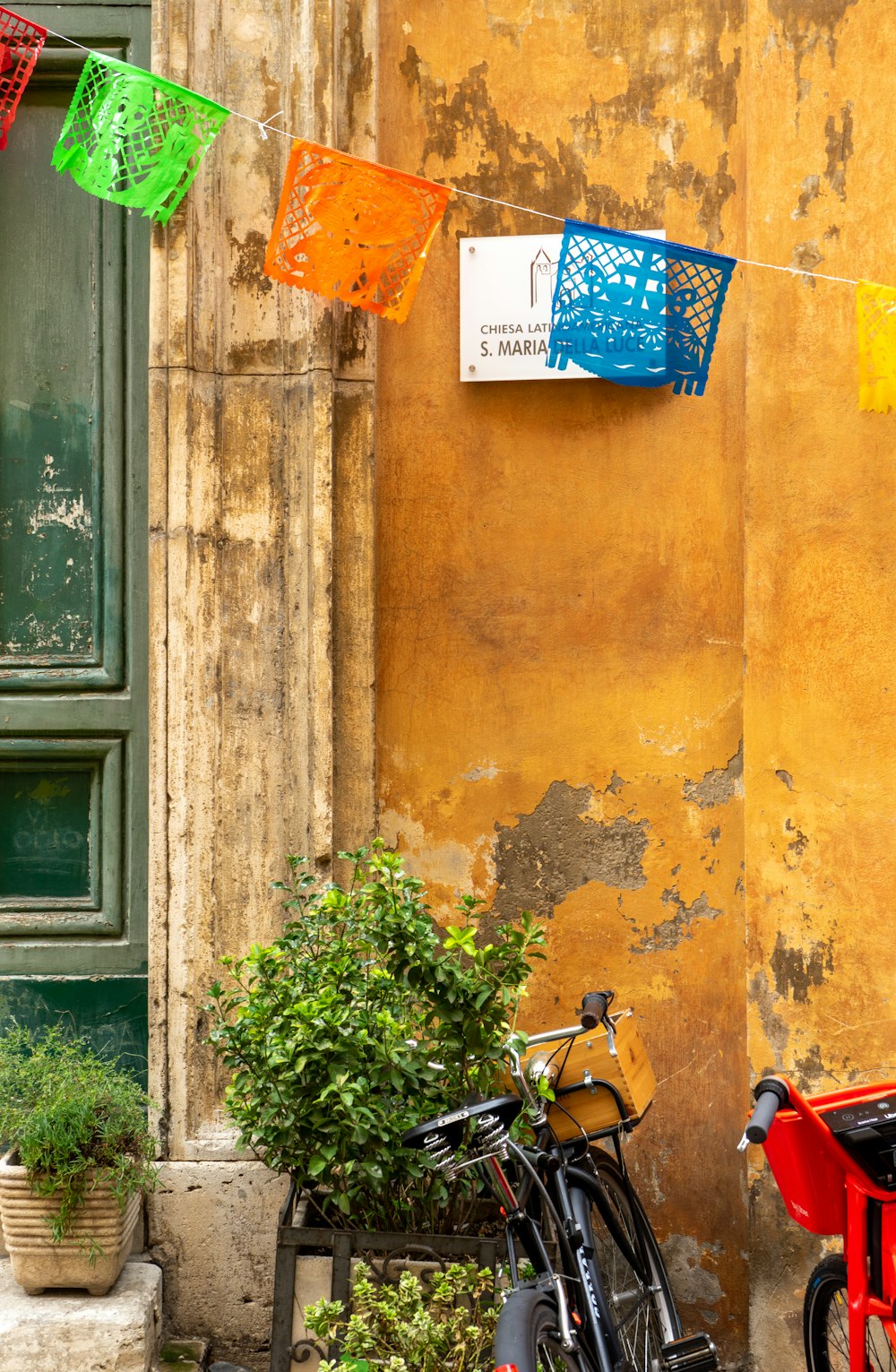 red and black motorcycle parked beside yellow wall