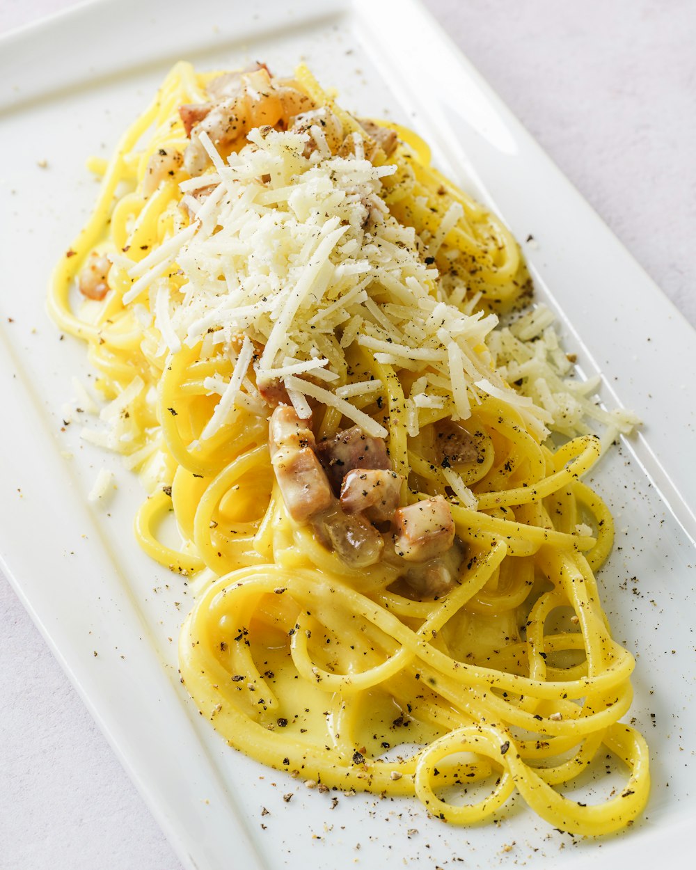 Plato de pasta sobre plato de cerámica blanca