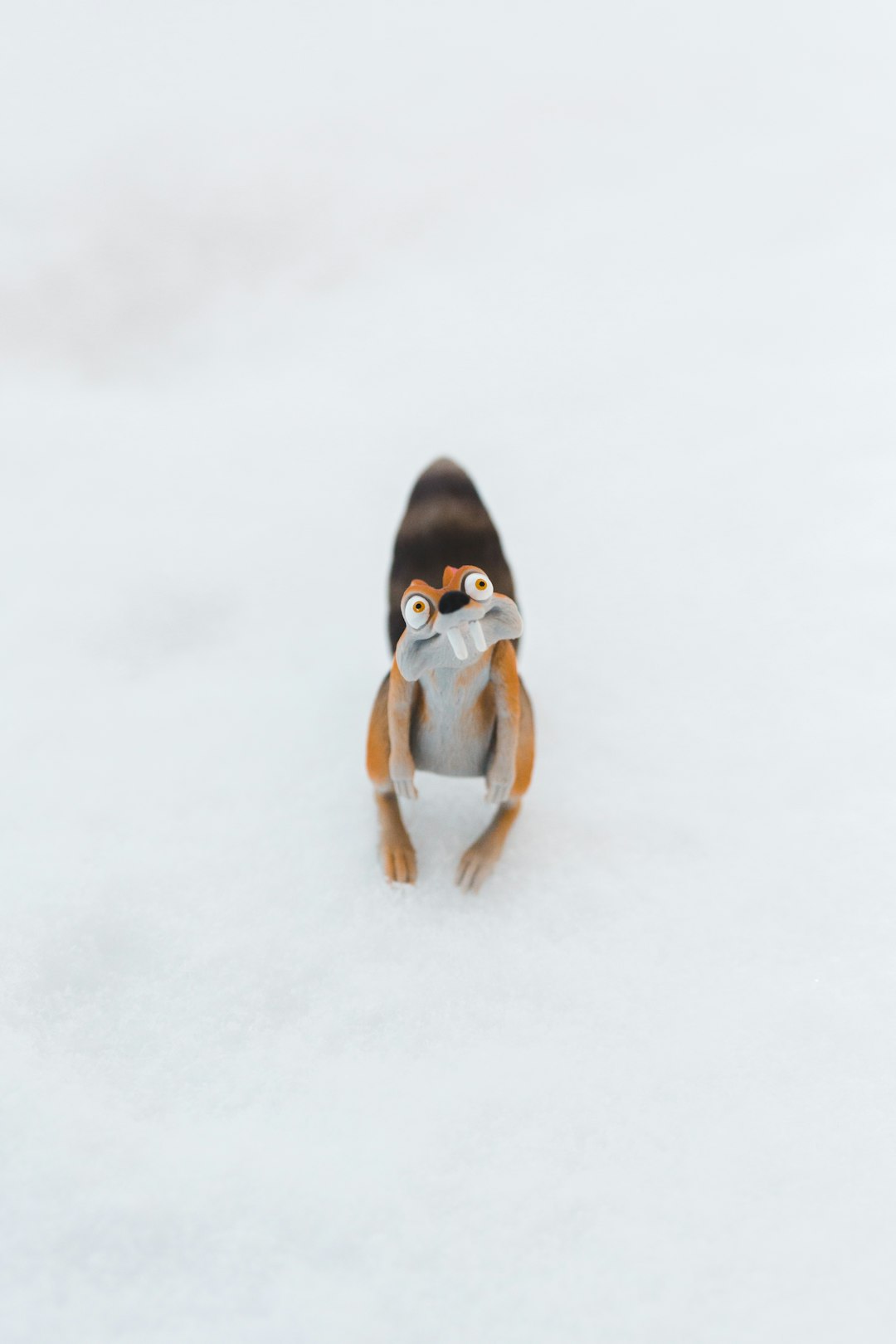 brown and white dog figurine on snow covered ground