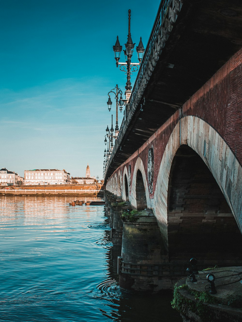 brown concrete bridge over body of water during daytime