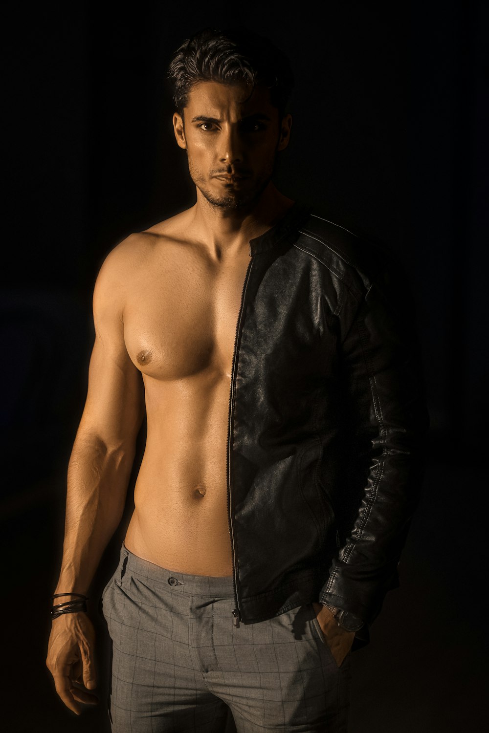 topless man in black leather jacket