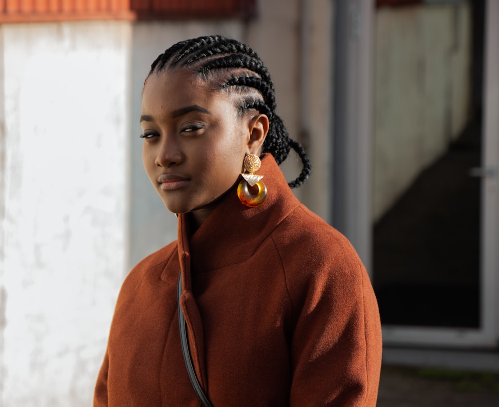 mulher no capuz laranja que veste o colar de ouro