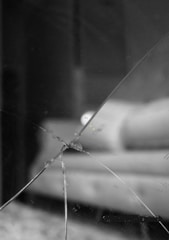 Close-up of a cracked windshield being repaired in a shop setting.