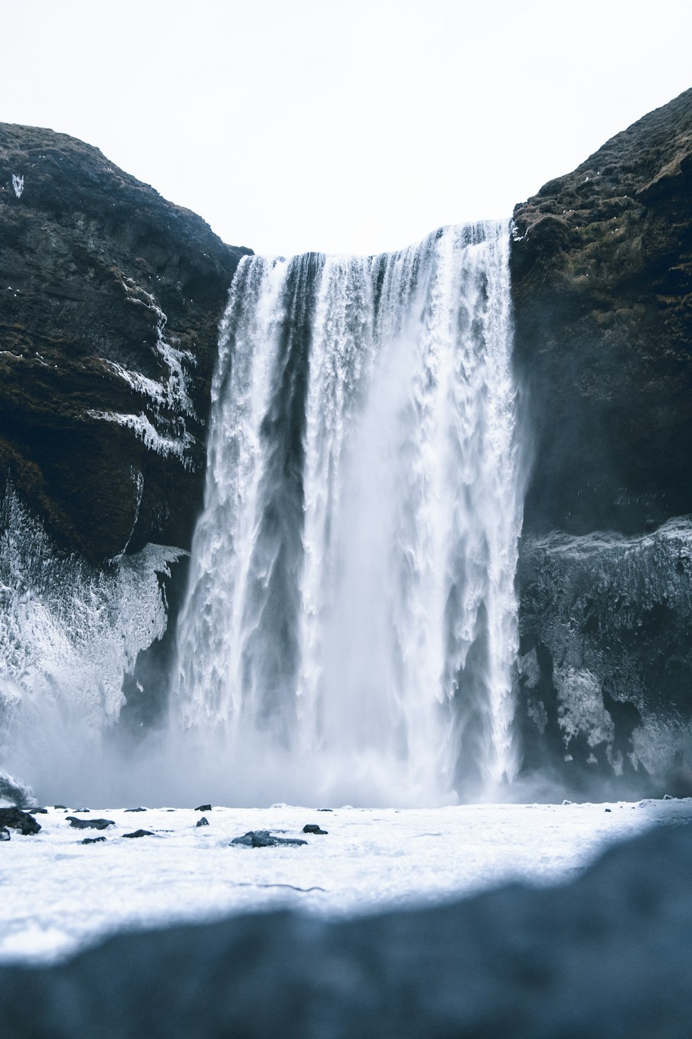 water falls on rocky shore during daytime