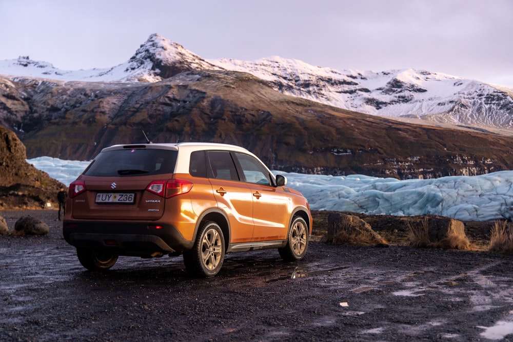 yellow mercedes benz suv on rocky shore during daytime