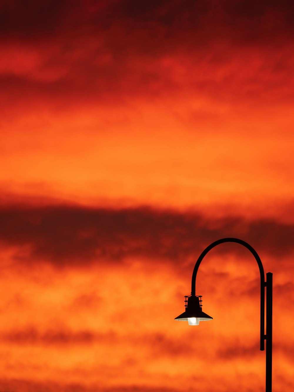 black street lamp under orange and blue sky