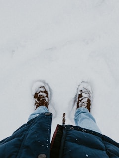 A man wearing winter boots walking through a snowy landscape, showcasing warmth and style.