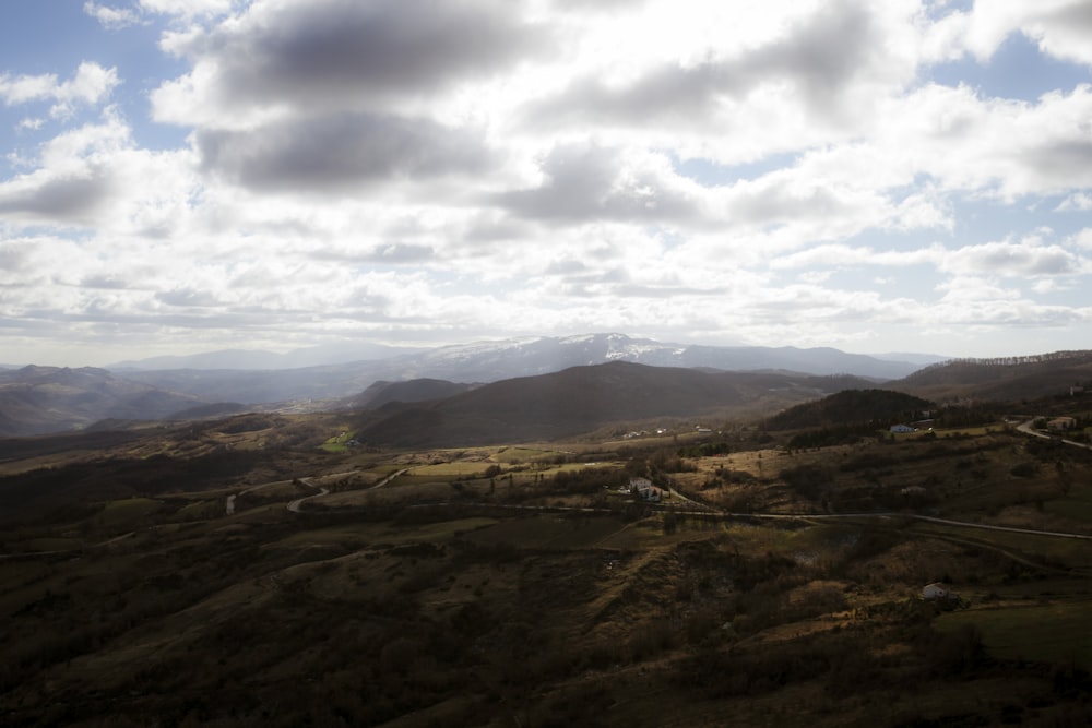 Montagnes brunes sous des nuages blancs pendant la journée