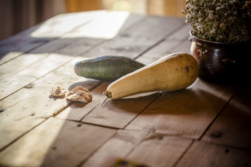A warm autumn salad featuring roasted squash, kale, and toasted nuts on a rustic wooden table.
