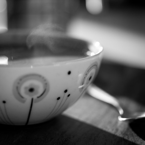 Close-up of a beautifully designed coffee cup with steam rising from it.