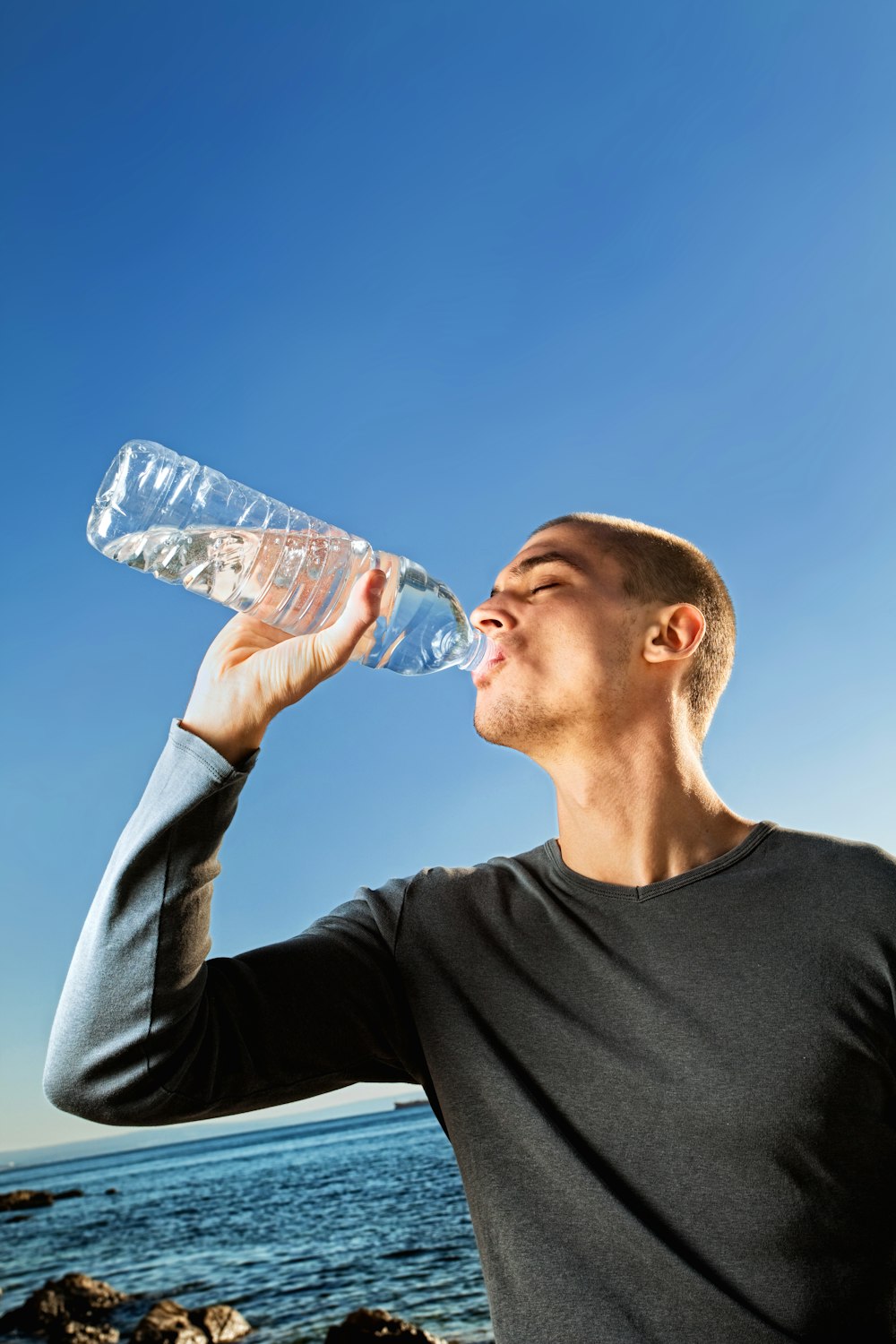 man in black crew neck shirt drinking water