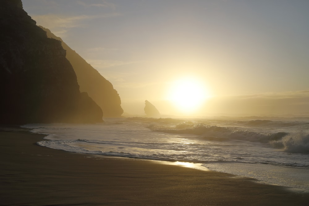 silhouette of mountain near body of water during sunset