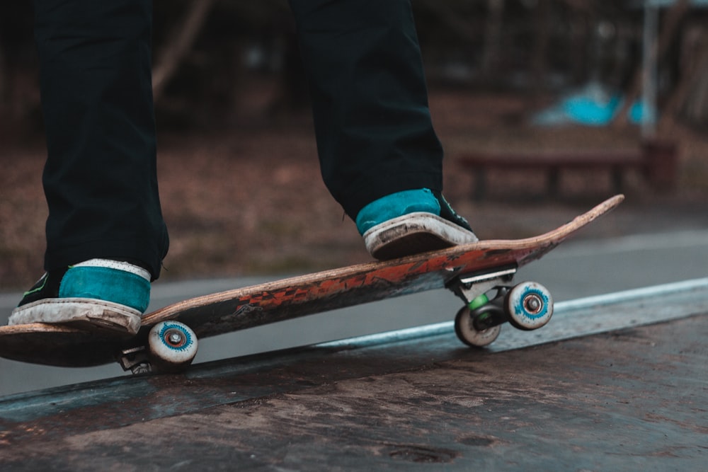 person in black pants riding on brown skateboard