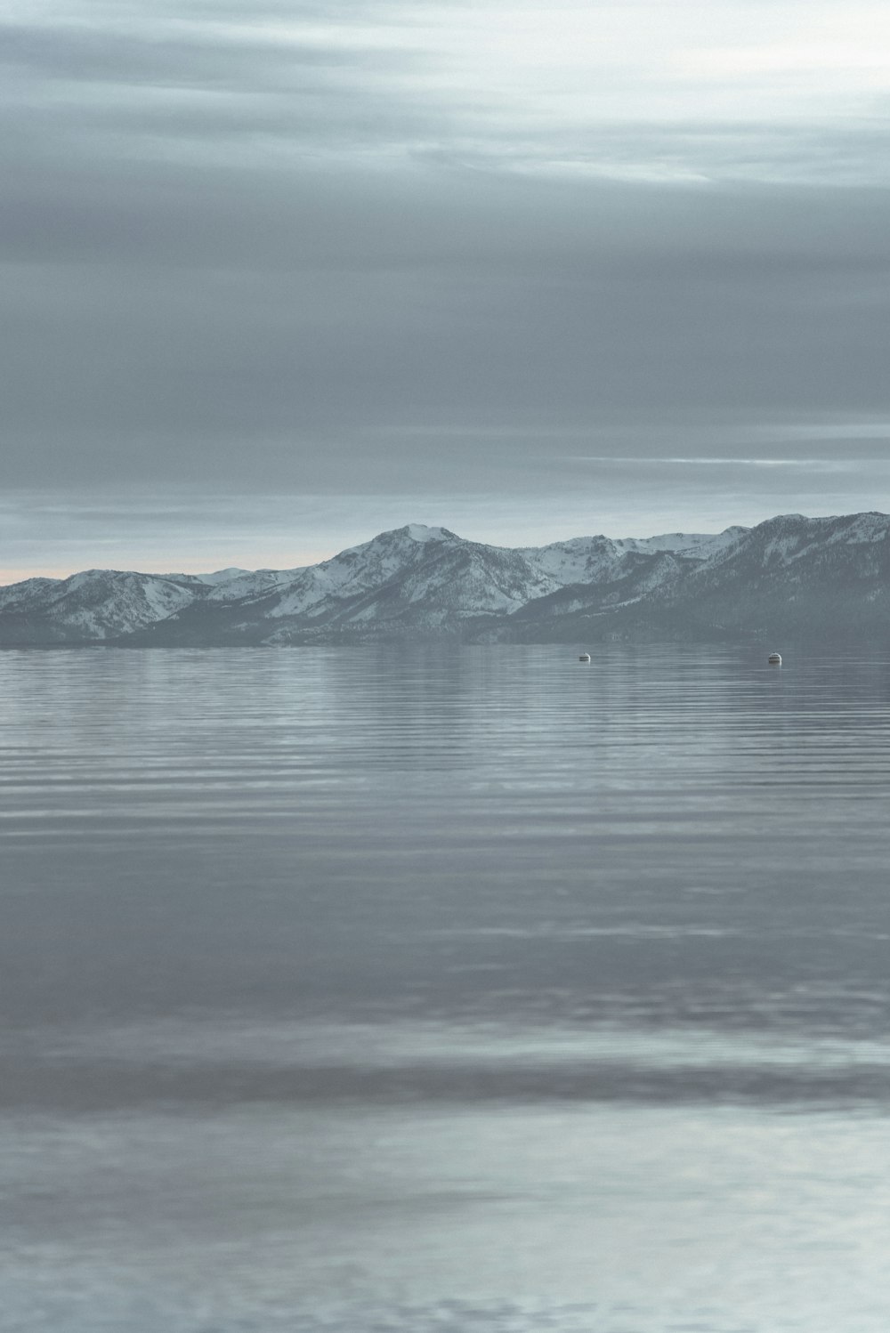 body of water near mountain during daytime