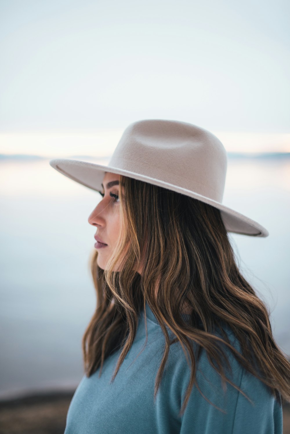 woman in blue shirt wearing white fedora hat