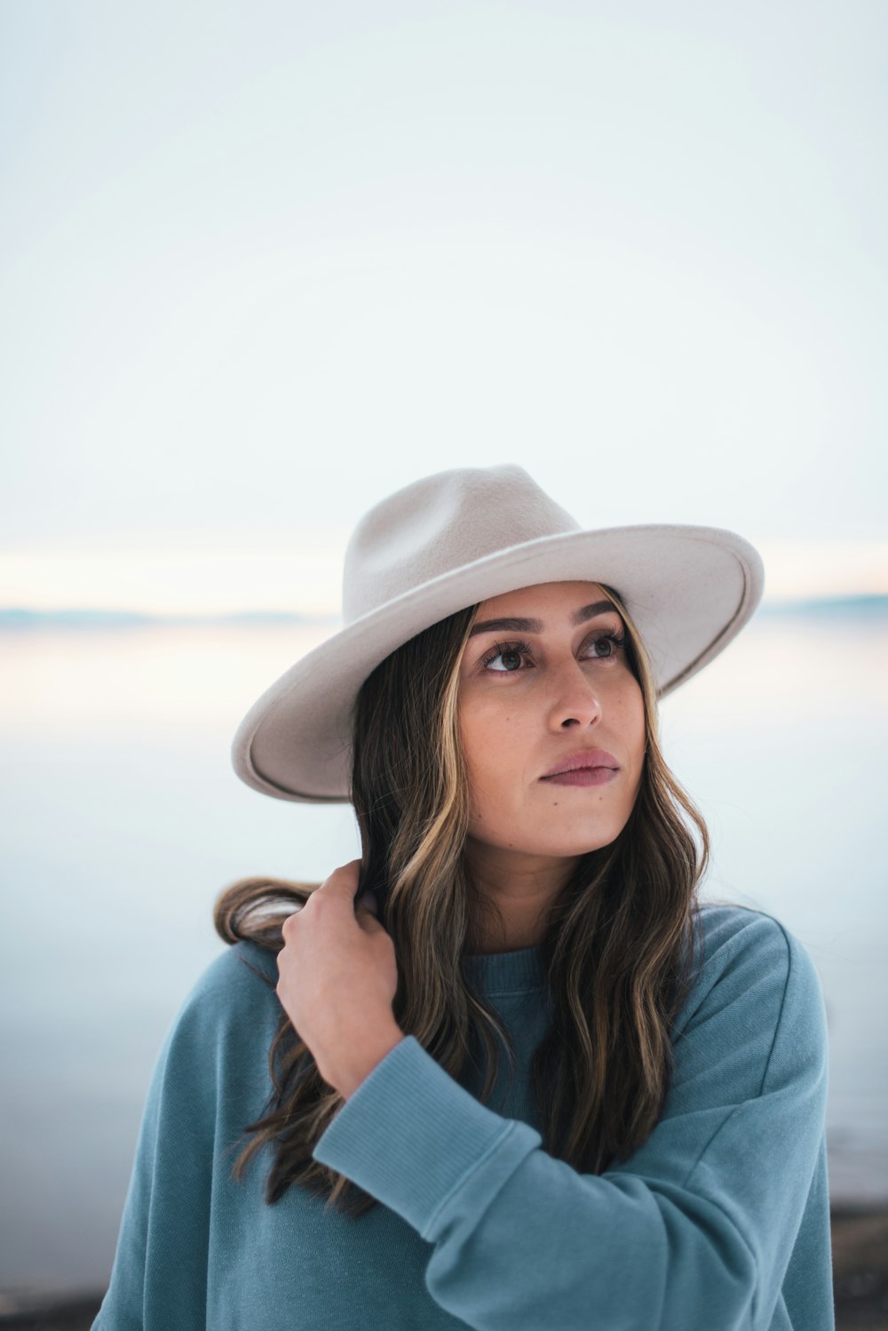 woman in blue shirt wearing white fedora hat