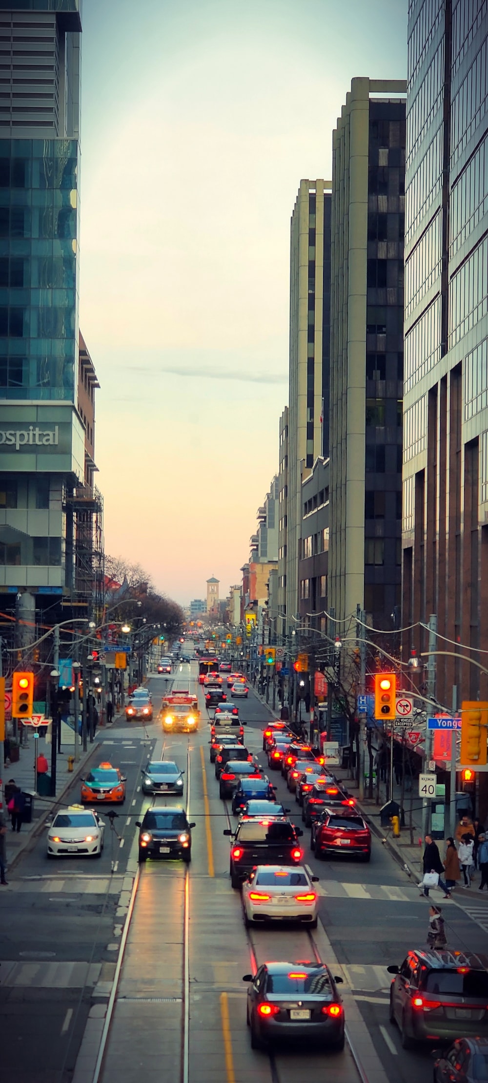 cars on road between high rise buildings during daytime