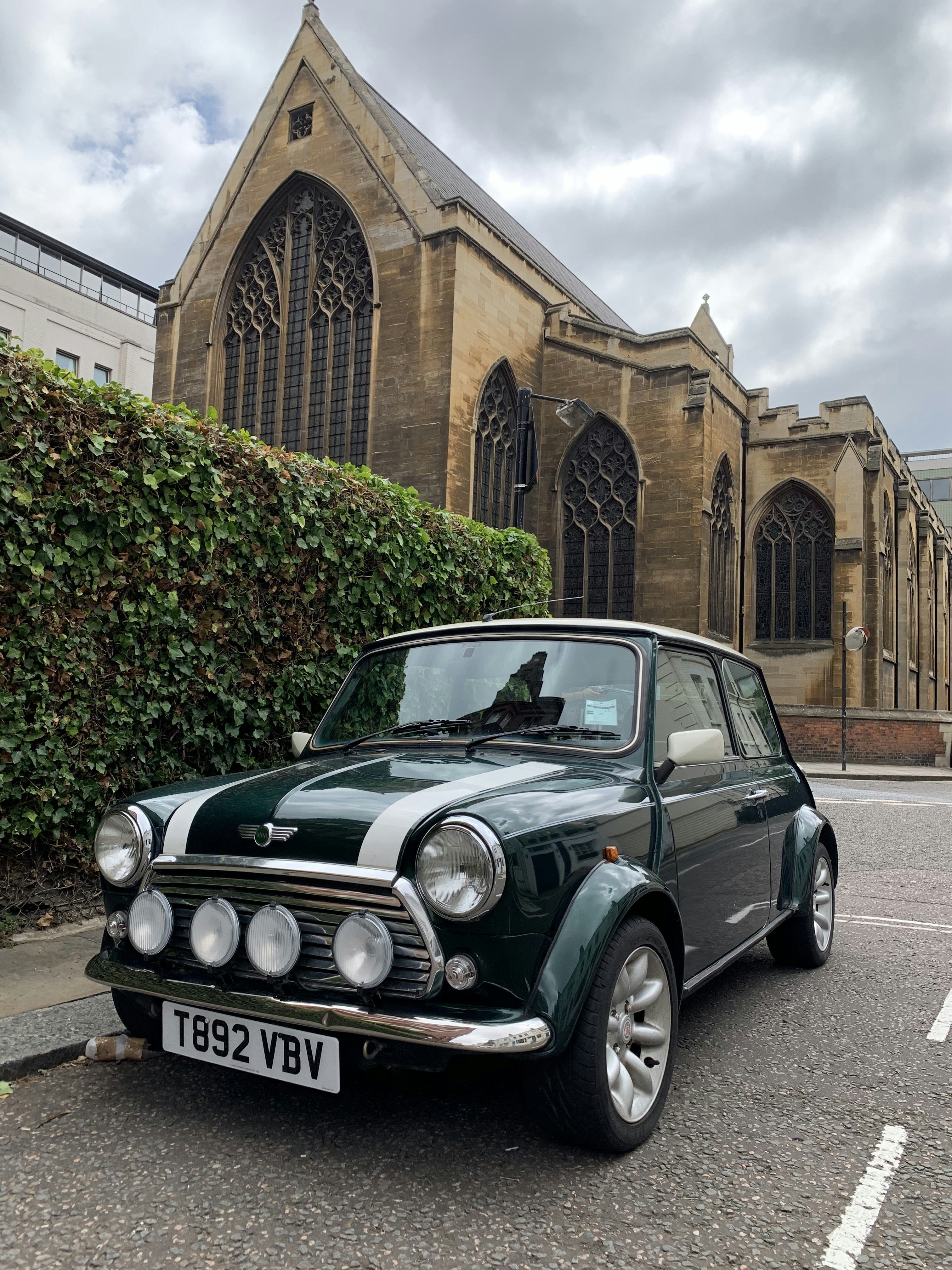 Grünes Mercedes-Benz-Coupé tagsüber neben braunem Betongebäude geparkt