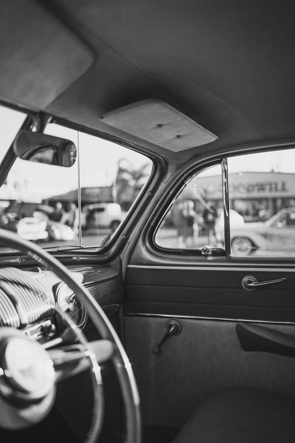 grayscale photo of car steering wheel