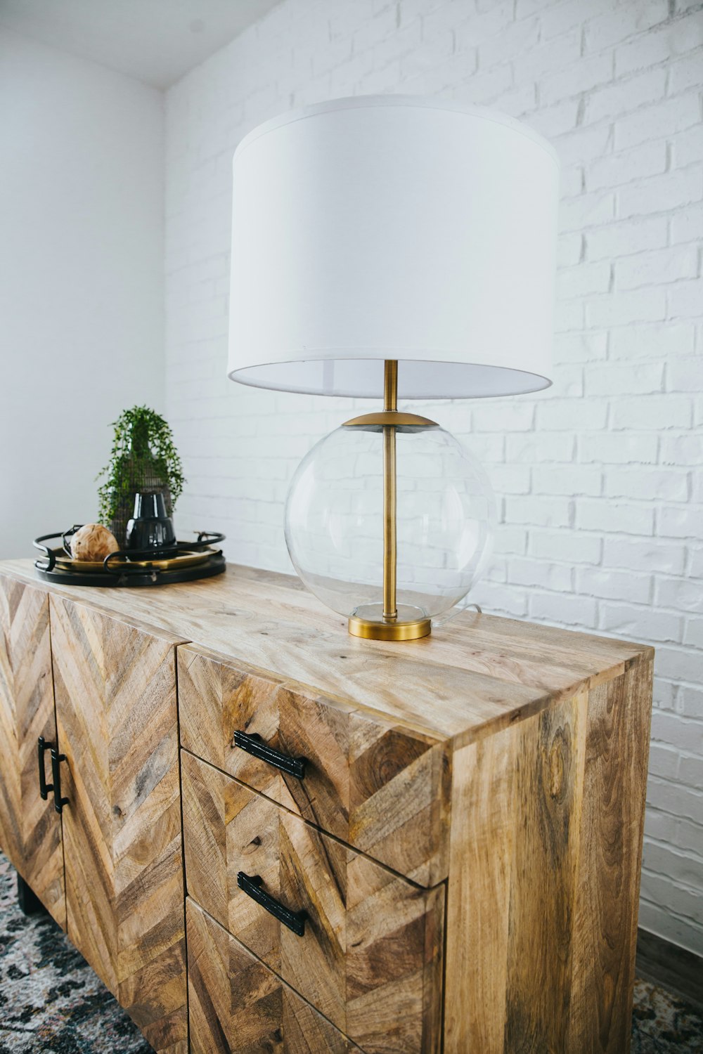 Lámpara de mesa dorada y blanca sobre mesa de madera marrón