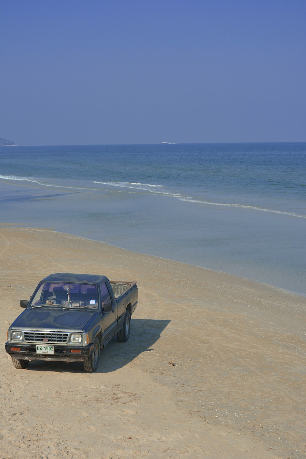 carro preto na praia durante o dia