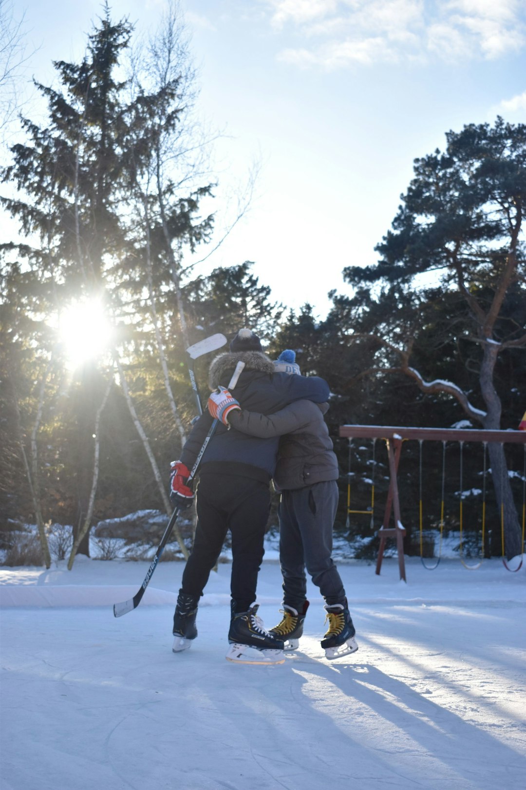 man in black jacket and blue denim jeans riding on ski blades on snow covered ground