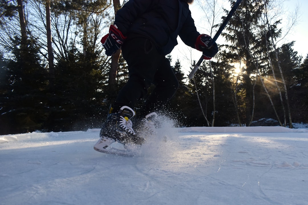 person in black jacket and black pants riding on white snowboard during daytime