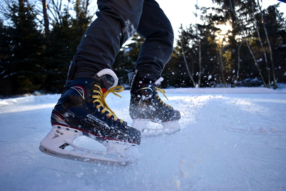 person in black pants and white orange and black snow shoes riding on white snow board