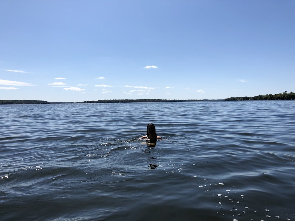 woman in black bikini on water during daytime