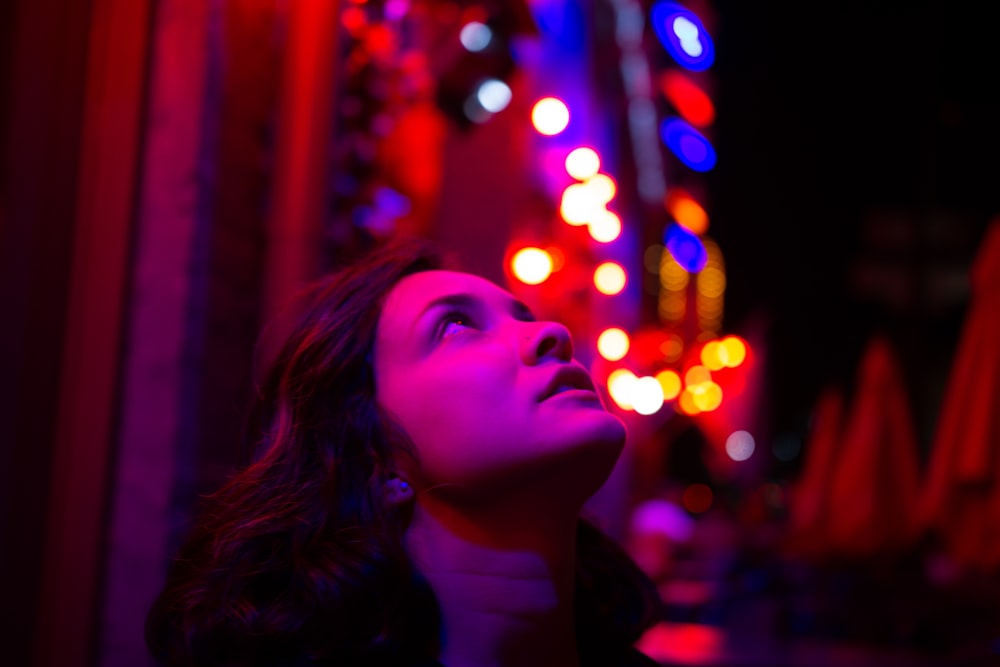 woman in black shirt with string lights on her face